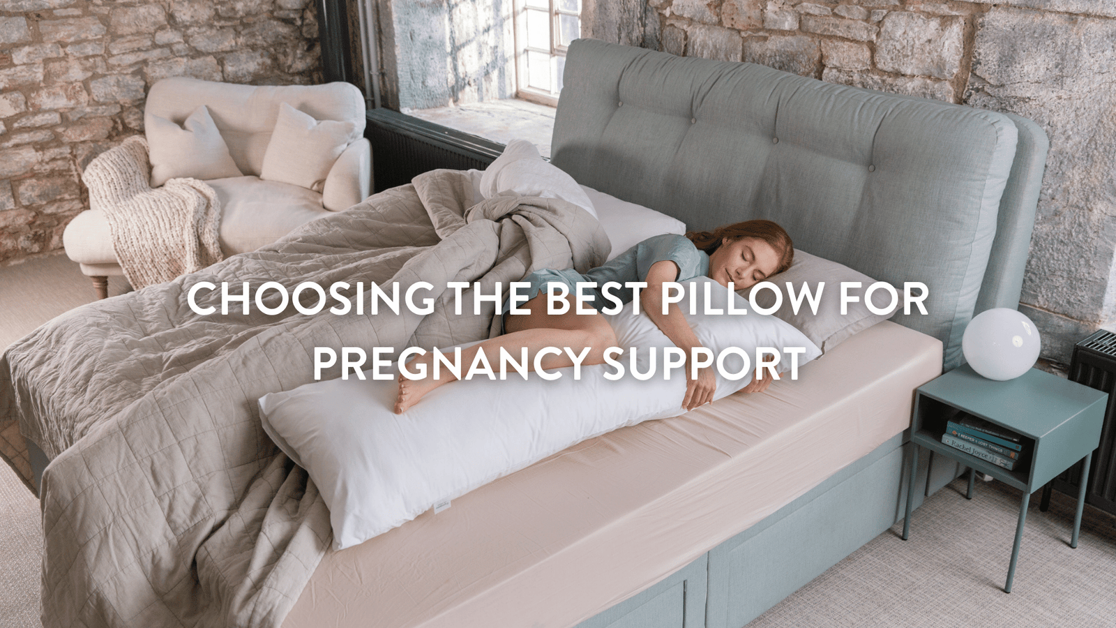 Person lying on a bed using a Putnams pregnancy support pillow