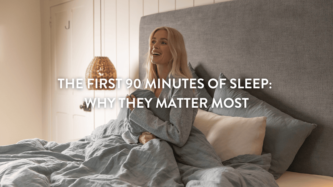 Person sitting up in bed surrounded by Putnams pillows and covered with a grey Putnams British wool duvet