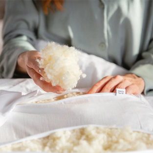 Natural pillows made with alternatives to foam, including British wool, organic buckwheat hulls, graphite latex, and 100% cotton, ideal for sleep, pregnancy and more